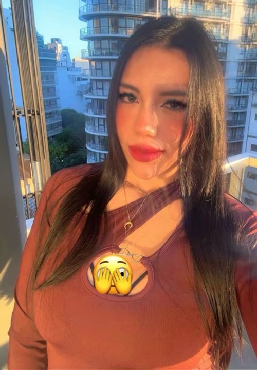 Woman on a balcony at golden hour, about to start a random video chat on her phone