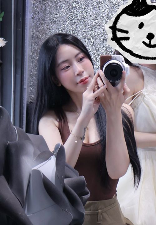 Woman holding a camera in a mirror, relaxed and ready for the next conversation
